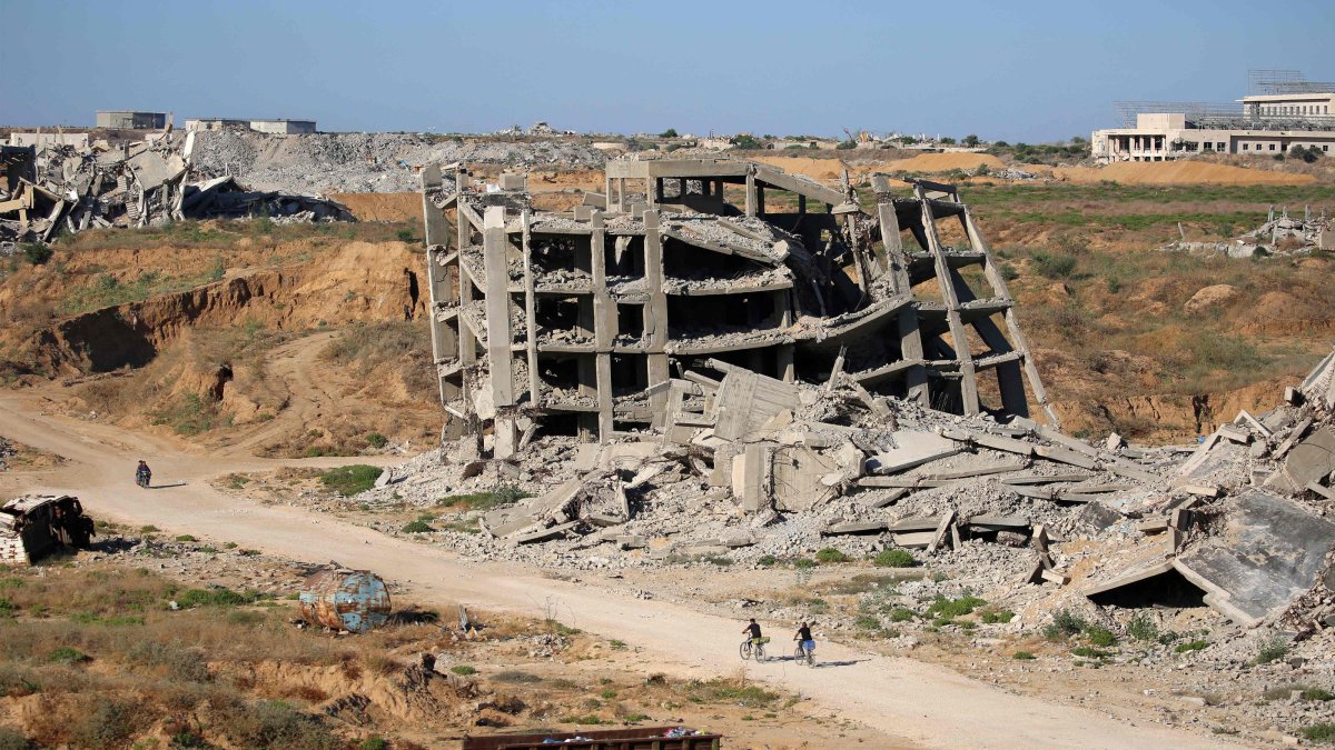 Men ride bicycles past a heavily-damaged building at the Nuseirat camp for Palestinian refugees in the central Gaza Strip, June 19, 2026. (AFP Photo)
