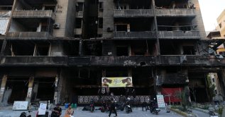 Supporters of Hezbollah hang a banner depicting portraits of late Hezbollah leaders Hassan Nasrallah and Hashem Safieddine in a partially damaged building targeted by an Israeli strike, in the southern suburbs of Beirut, Lebanon,  June 17, 2026. (EPA Photo)