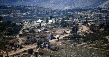An Israeli flag hangs from a damaged building in a village inside south Lebanon close to the border as seen from northern Israel, June 18, 2026. (Reuters Photo)