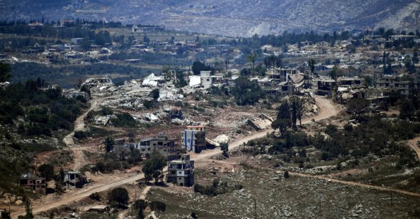 An Israeli flag hangs from a damaged building in a village inside south Lebanon close to the border as seen from northern Israel, June 18, 2026. (Reuters Photo)