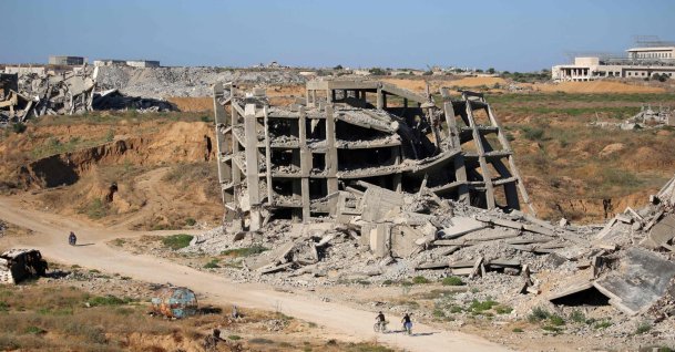 Men ride bicycles past a heavily-damaged building at the Nuseirat camp for Palestinian refugees in the central Gaza Strip, June 19, 2026. (AFP Photo)