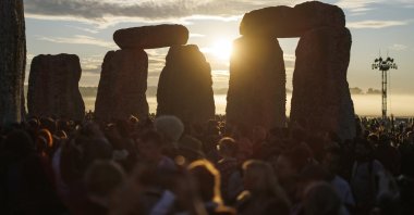 People watching the sunrise during the summer solstice celebrations at the ancient Stonehenge monument in Wiltshire, Britain, June 21, 2026. (EPA Photo)