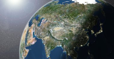 A true-color satellite image of the Earth showing Asia, half in shadow, and the sun. (Getty Images Photo)