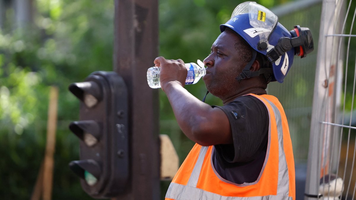 A worker drinks water at a construction site as temperatures rise during a heatwave, Paris, France, June 22, 2026. (Reuters Photo)