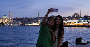 Tourists click for a photo with a backdrop of Galata Bridge and mosques in Istanbul, Türkiye, June 18, 2026. (AA Photo)