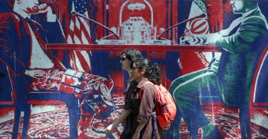 Iranian girls walk past an anti-U.S. mural next to the former U.S. embassy in Tehran, Iran, June 22, 2026. (EPA Photo)