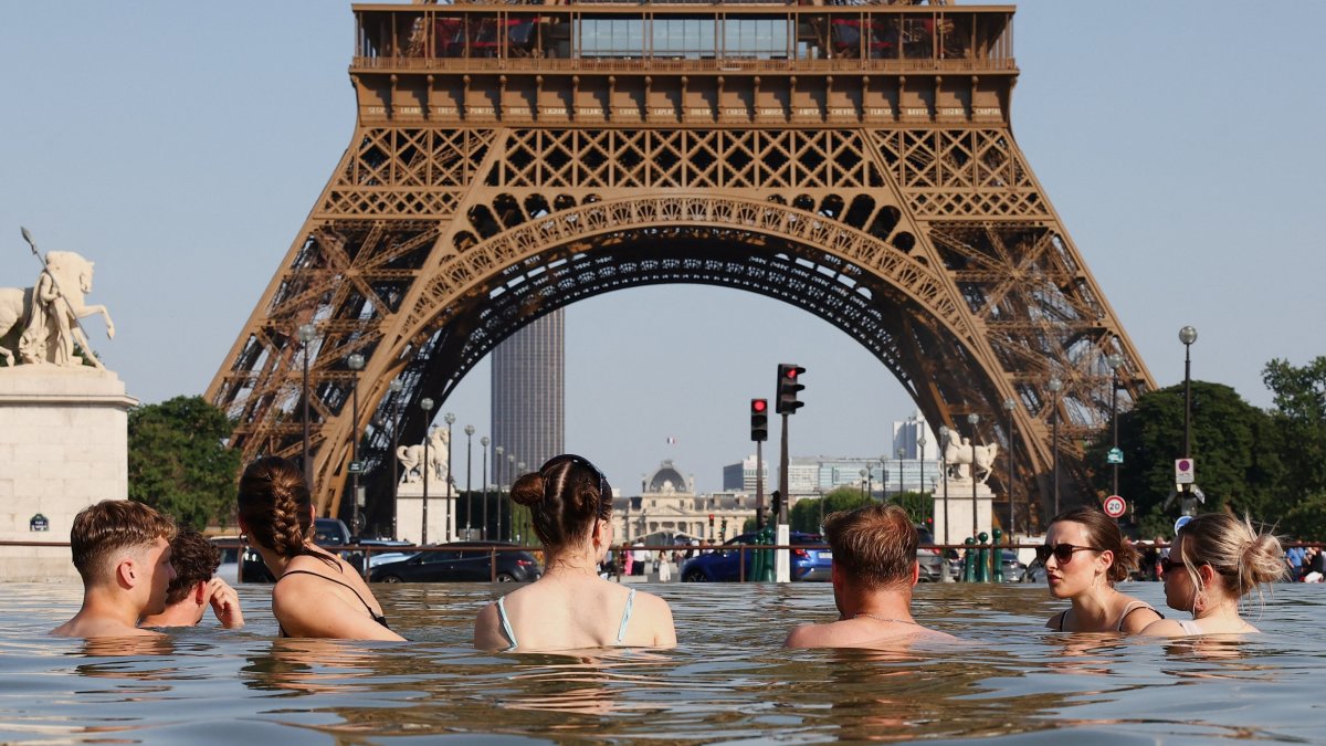 People cool off in the Trocadero Fountain next to the Eiffel Tower as temperatures rise during a heatwave affecting a large part of the country, Paris, France, June 22, 2026. (Reuters Photo)