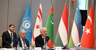Flags of countries members of the Organization of Turkic States (OTS) are seen behind officials during a meeting in Shusha, Azerbaijan, June 13, 2026. (AA Photo)
