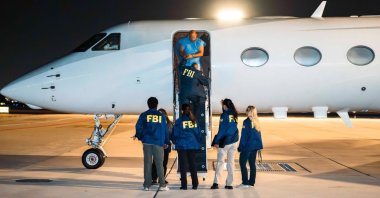 Federal Bureau of Investigation (FBI) agents escort the suspect to an aircraft following his detention in Türkiye. (Courtesy of FBI)