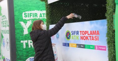 A woman dumps a plastic bottle inside a recycling container spot, in Konya, central Türkiye, Nov. 19, 2021. (AA Photo)