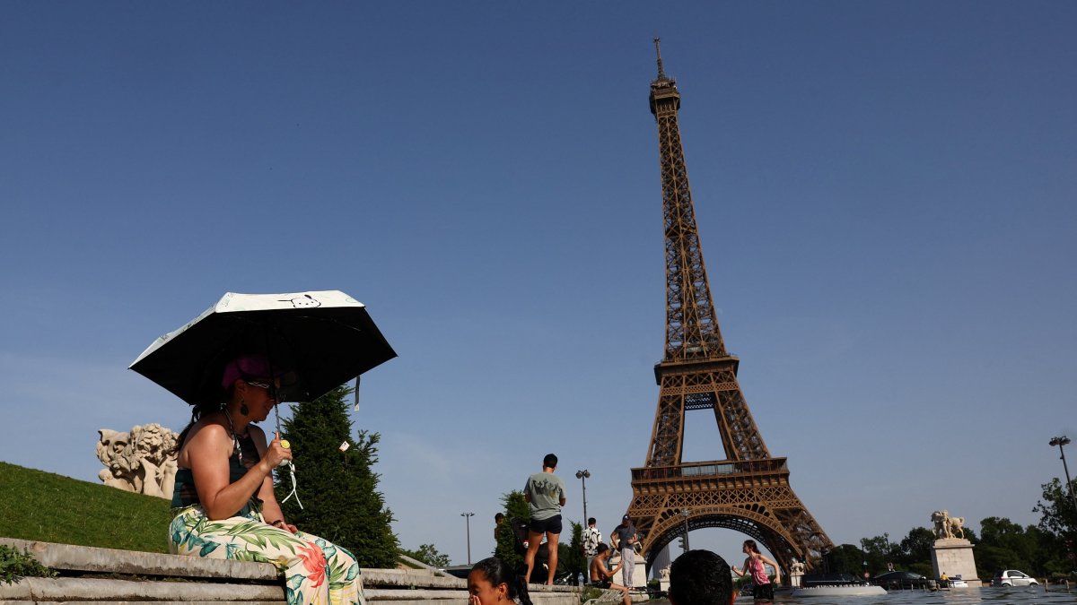 People cool off in the Trocadero fountain in front of the Eiffel Tower as temperatures rise during a heatwave, Paris, France, June 23, 2026. (Reuters Photo)