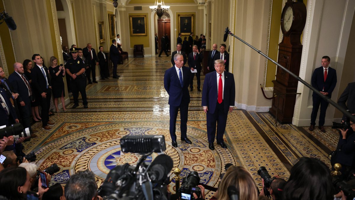 U.S. Senate Majority Leader John Thune (R-SD) (L) watches as U.S. President Donald Trump speaks to the media as they arrive at the U.S. Capitol, Washington, D.C., June 24, 2026. (AFP Photo)