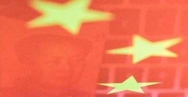 China yuan banknote featuring late Chinese leader Mao Zedong and a computer keyboard are seen reflected on an image of the Chinese flag in this illustration picture taken Nov. 1, 2019. (Reuters Photo)