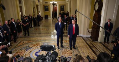 U.S. Senate Majority Leader John Thune (R-SD) (L) watches as U.S. President Donald Trump speaks to the media as they arrive at the U.S. Capitol, Washington, D.C., June 24, 2026. (AFP Photo)