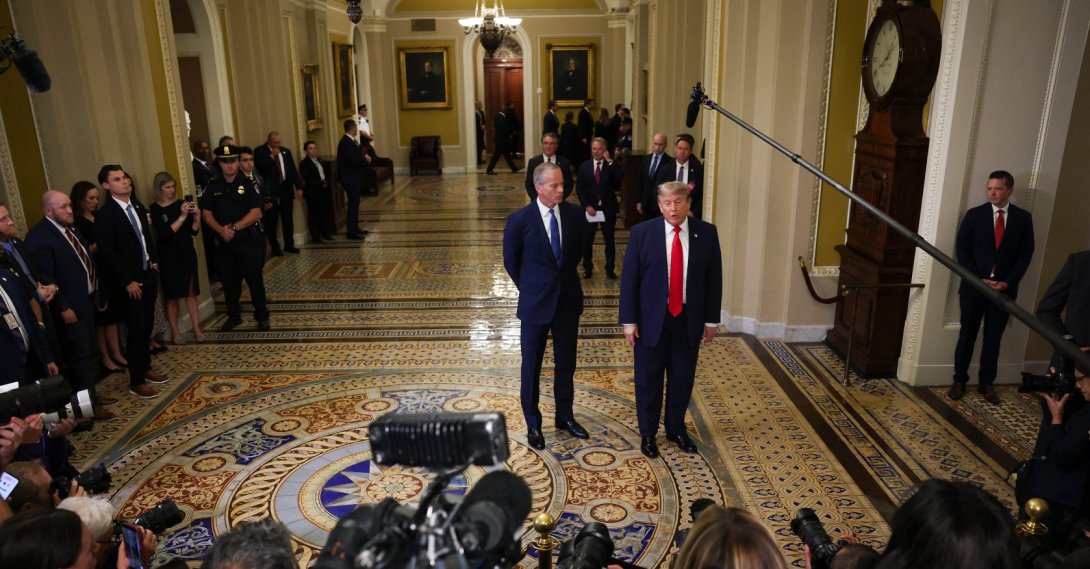 U.S. Senate Majority Leader John Thune (R-SD) (L) watches as U.S. President Donald Trump speaks to the media as they arrive at the U.S. Capitol, Washington, D.C., June 24, 2026. (AFP Photo)