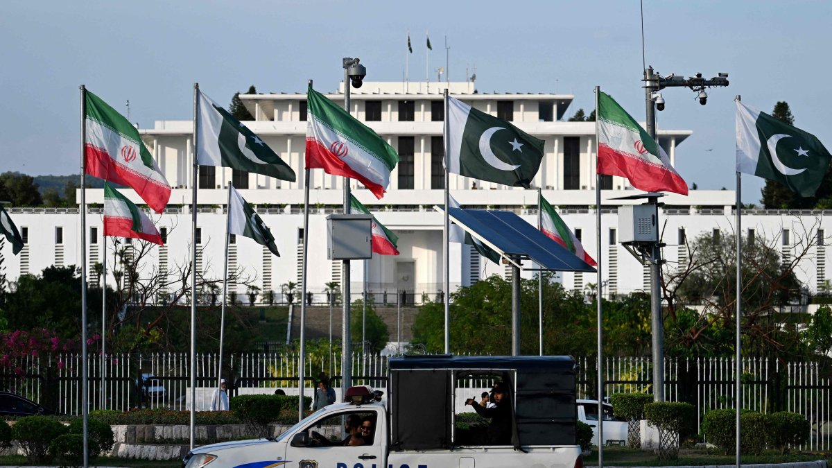 Police personnel ride past the national flags of Pakistan and Iran fluttering outside the President's House, Islamabad, Pakistan, June 22, 2026. (AFP Photo)
