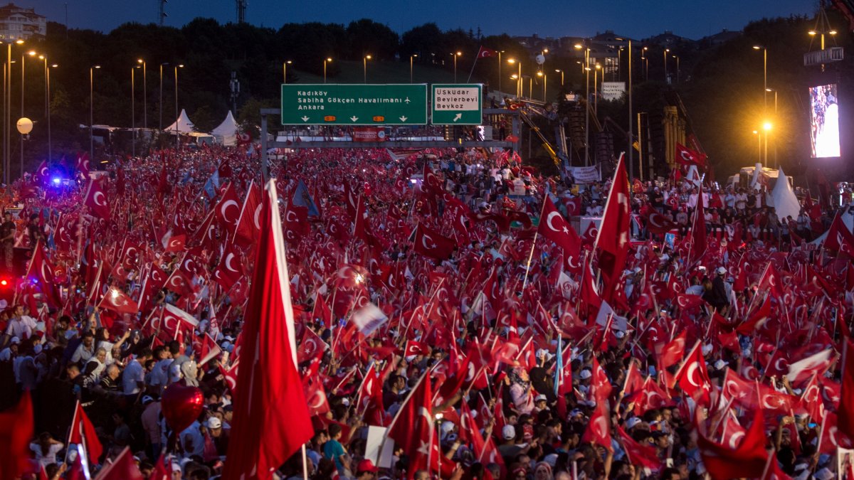 People wave flags as they wait for official ceremonies to begin on the first anniversary of the 2016 failed coup attempt, Istanbul, Türkiye, July 15, 2017. (Getty Images Photo)
