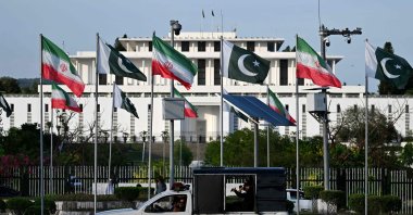 Police personnel ride past the national flags of Pakistan and Iran fluttering outside the President's House, Islamabad, Pakistan, June 22, 2026. (AFP Photo)