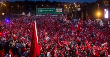 People wave flags as they wait for official ceremonies to begin on the first anniversary of the 2016 failed coup attempt, Istanbul, Türkiye, July 15, 2017. (Getty Images Photo)