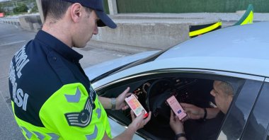 A gendarmerie officer introduces the HAYAT 112 Emergency mobile application to a driver during a public awareness campaign, Gaziantep, Türkiye, May 30, 2026. (IHA Photo)