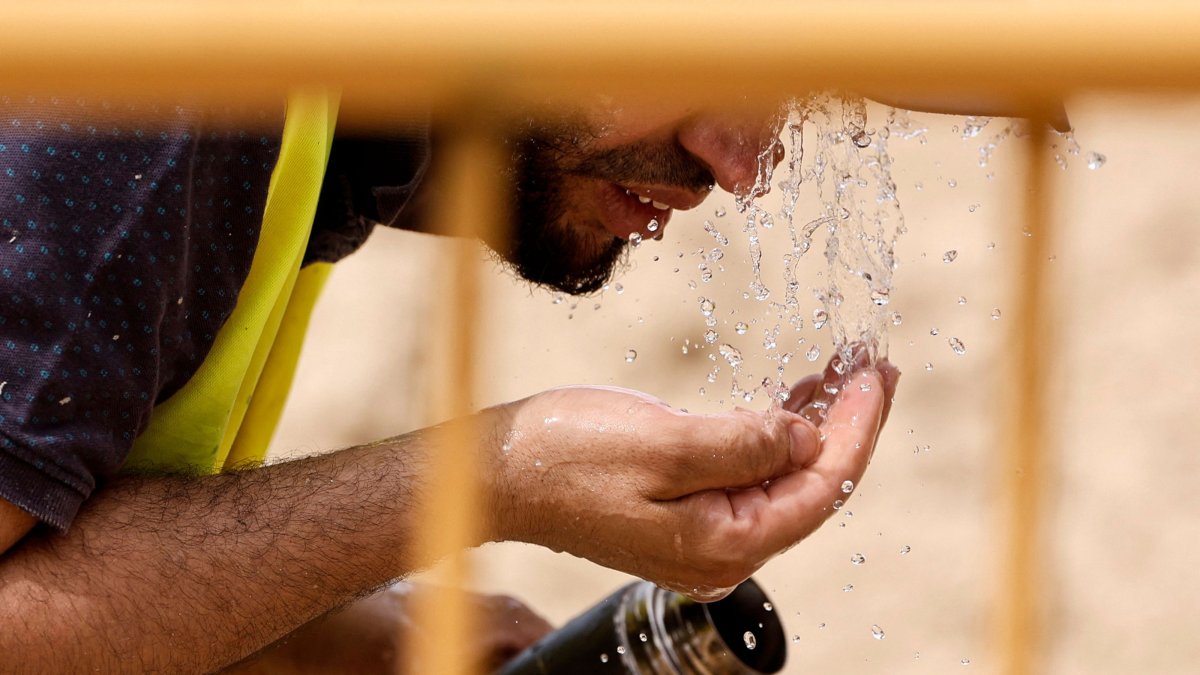 A worker cools off with water at a road construction site during the heat wave affecting the Iberian Peninsula, Madrid, Sapin, June 22, 2026. (AFP Photo)