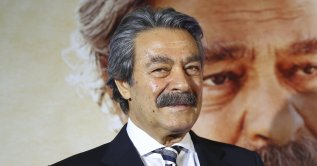 Kadir Inanır poses for photographers in front of the poster of his film Kapı during the movie's premiere, Istanbul, April 10, 2019. (AA File Photo)