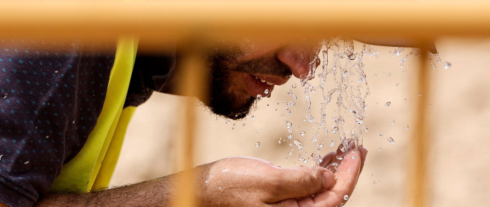 A worker cools off with water at a road construction site during the heat wave affecting the Iberian Peninsula, Madrid, Sapin, June 22, 2026. (AFP Photo)