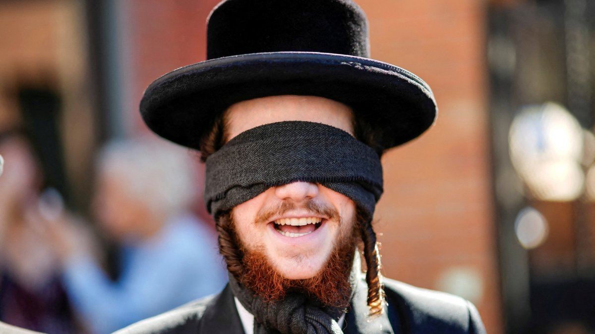 A Jewish member of the Neturei Karta organization supporting Palestine covers his eyes as protesters take part in an "EndJewHatred" rally outside Poetica Coffee, following a social media post by the shop targeting Jewish Congressman Dan Goldman and denying service to pro‑Israel customers, Brooklyn, New York, U.S., June 24, 2026. (Reuters Photo)