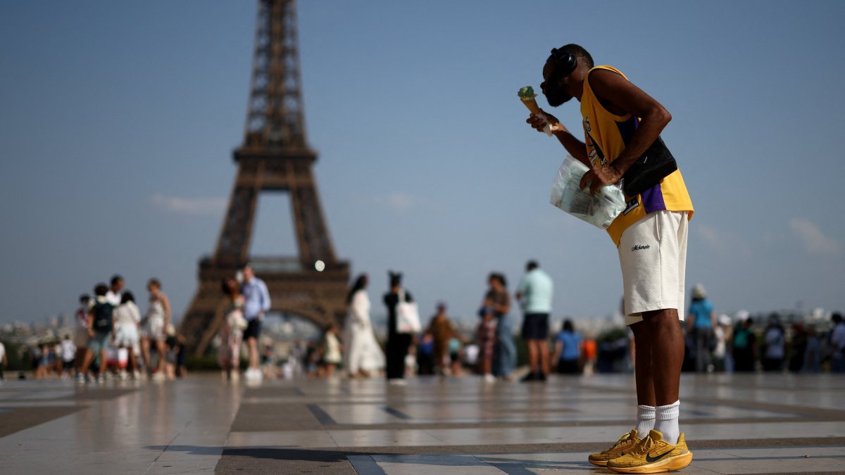 A person eats ice cream in front of the Eiffel Tower during a heatwave in Paris, France, June 27, 2026. (Reuters Photo)