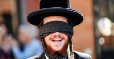 A Jewish member of the Neturei Karta organization supporting Palestine covers his eyes as protesters take part in an "EndJewHatred" rally outside Poetica Coffee, following a social media post by the shop targeting Jewish Congressman Dan Goldman and denying service to pro‑Israel customers, Brooklyn, New York, U.S., June 24, 2026. (Reuters Photo)