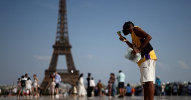 A person eats ice cream in front of the Eiffel Tower during a heatwave in Paris, France, June 27, 2026. (Reuters Photo)