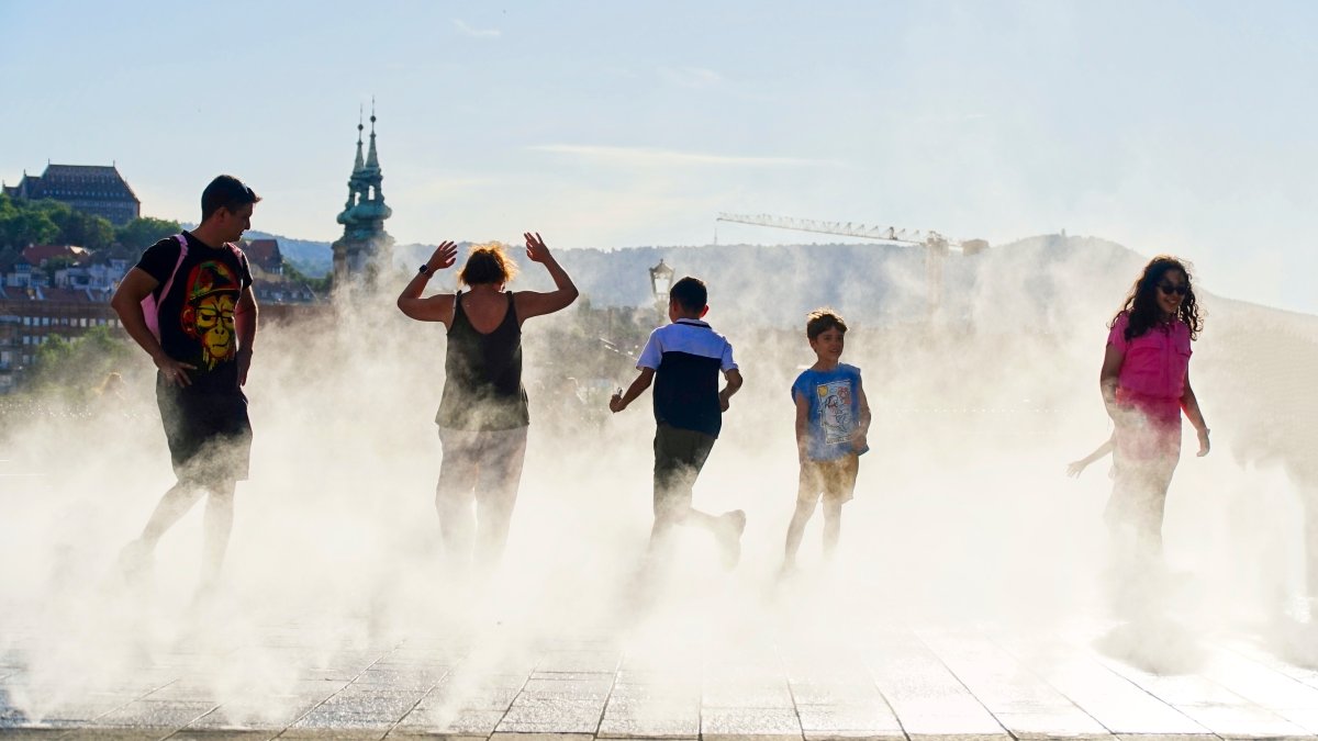 People enjoying the coolness of the water sprayers in the summer heat, Kossuth square, Budapest, Hungary, June 30, 2025. (Shutterstock Photo)