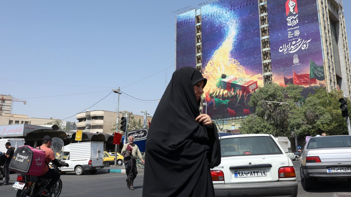 An Iranian woman walks past a billboard for the upcoming funeral of Iran's late Supreme Leader Ayatollah Ali Khamenei in Vanak Square, Tehran, Iran, June 29, 2026. (EPA Photo)