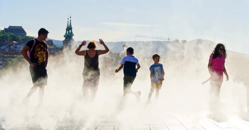People enjoying the coolness of the water sprayers in the summer heat, Kossuth square, Budapest, Hungary, June 30, 2025. (Shutterstock Photo)
