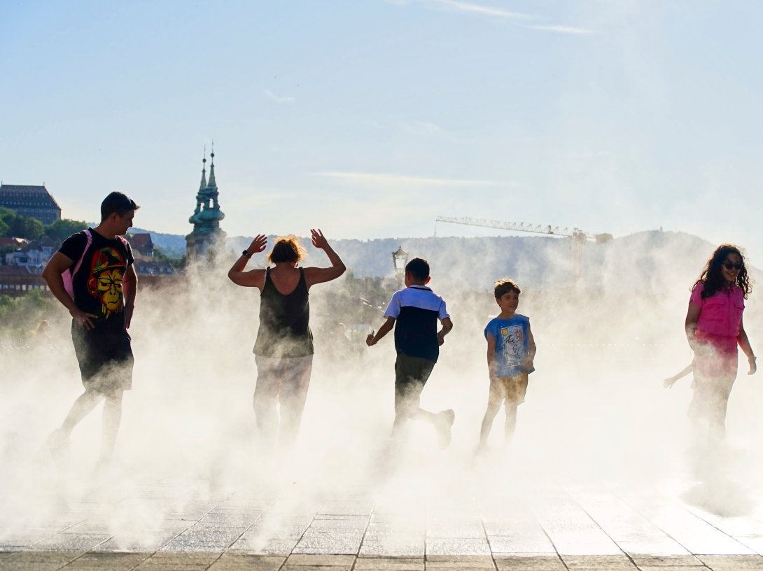 People enjoying the coolness of the water sprayers in the summer heat, Kossuth square, Budapest, Hungary, June 30, 2025. (Shutterstock Photo)
