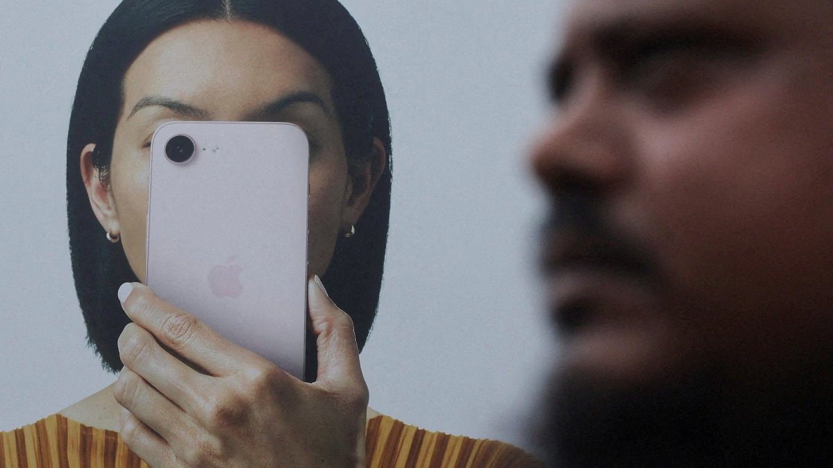 A man walks past an Apple iPhone hoarding on a street in Mumbai, India, June 29, 2026. (Reuters Photo)