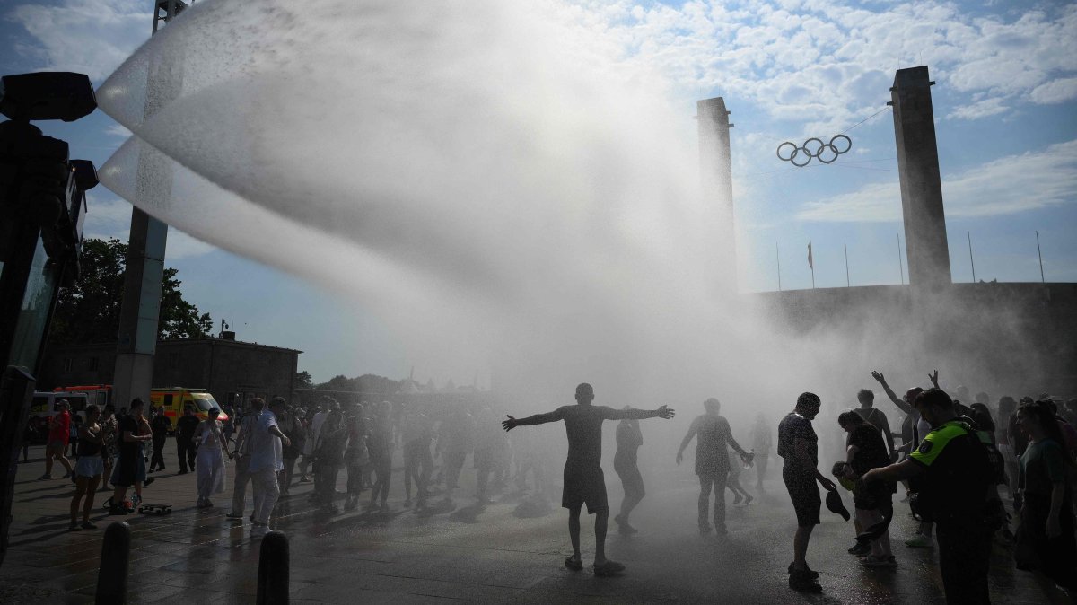 Police use water cannon to spray people with water amid heat wave as they arrive at the Olympic stadium for a concert of U.S. singer Bruno Mars, Berlin, Germany, June 28, 2026. (AFP Photo)