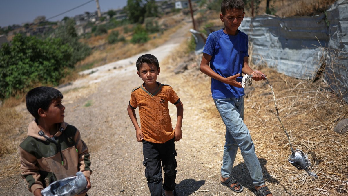 Local boys carry the remains of an exploded Israeli shell in the village of Abdin, Daraa province, Syria, June 29, 2026. (AP Photo)