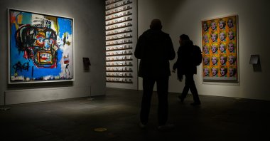 People move past Jean-Michel Basquiat’s Untitled (1982) and Marilyn Monroe (Twenty Times) (1992) (R) by Andy Warhol at Sotheby's Breuer building, New York, U.S., Dec. 13, 2025. (Getty Images Photo)