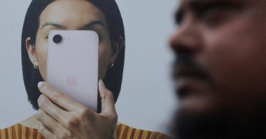 A man walks past an Apple iPhone hoarding on a street in Mumbai, India, June 29, 2026. (Reuters Photo)