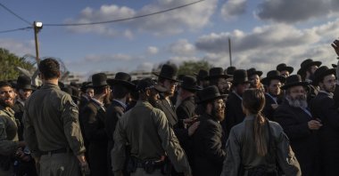 Israeli security forces stand guard as ultra-Orthodox Jews gather to protest against military conscription outside Bet Lid military prison in Kfar Yona, June 17, 2026. (AFP File Photo)