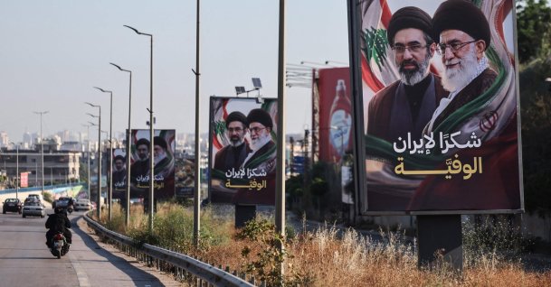 Cars and motorbikes drive past billboards showing Iran’s new Supreme Leader Ayatollah Mojtaba Khamenei (L) and his late father Ali Khamenei (R), with the slogan "Thank you, loyal Iran," erected along the highway leading to Rafic Hariri International Airport in Beirut, Lebanon, June 22, 2026. (AFP Photo)
