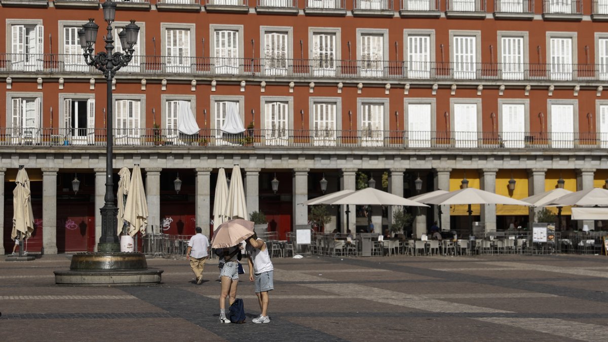 People use an umbrella to cover from the sun at Plaza Mayor in Madrid, Spain, June 23, 2026. (Getty Images Photo)