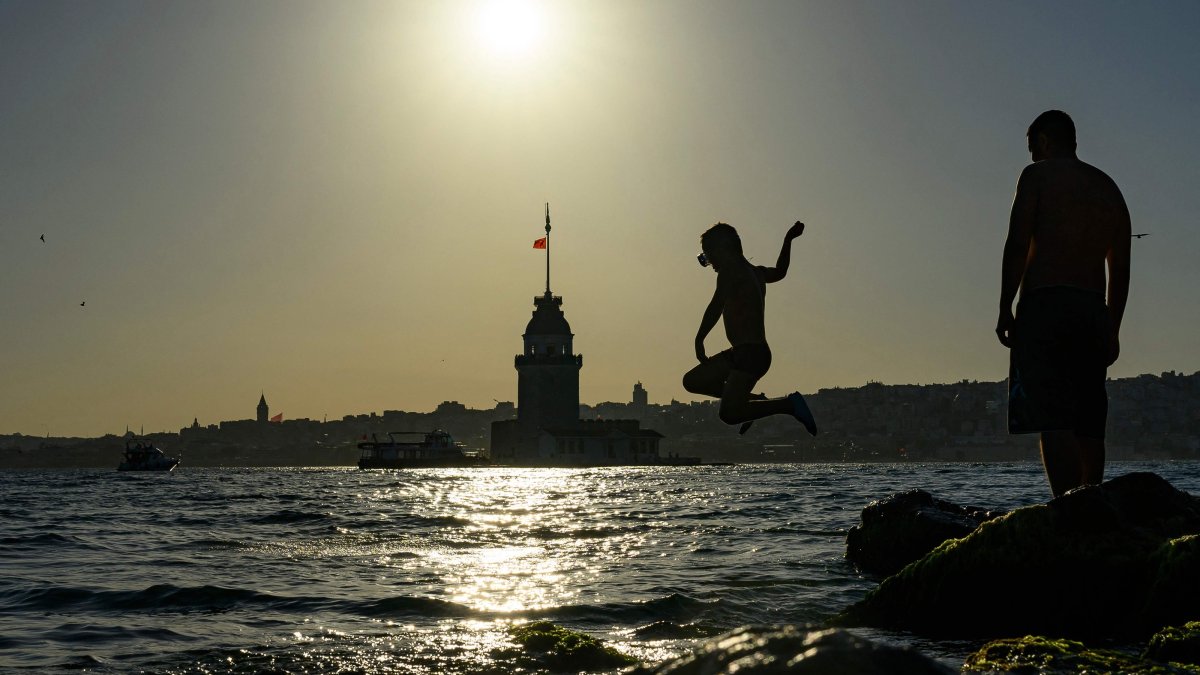 A child jumps into the sea near Maiden’s Tower as people seek relief from warm weather in Istanbul, Türkiye, June 28, 2026. (AFP Photo)
