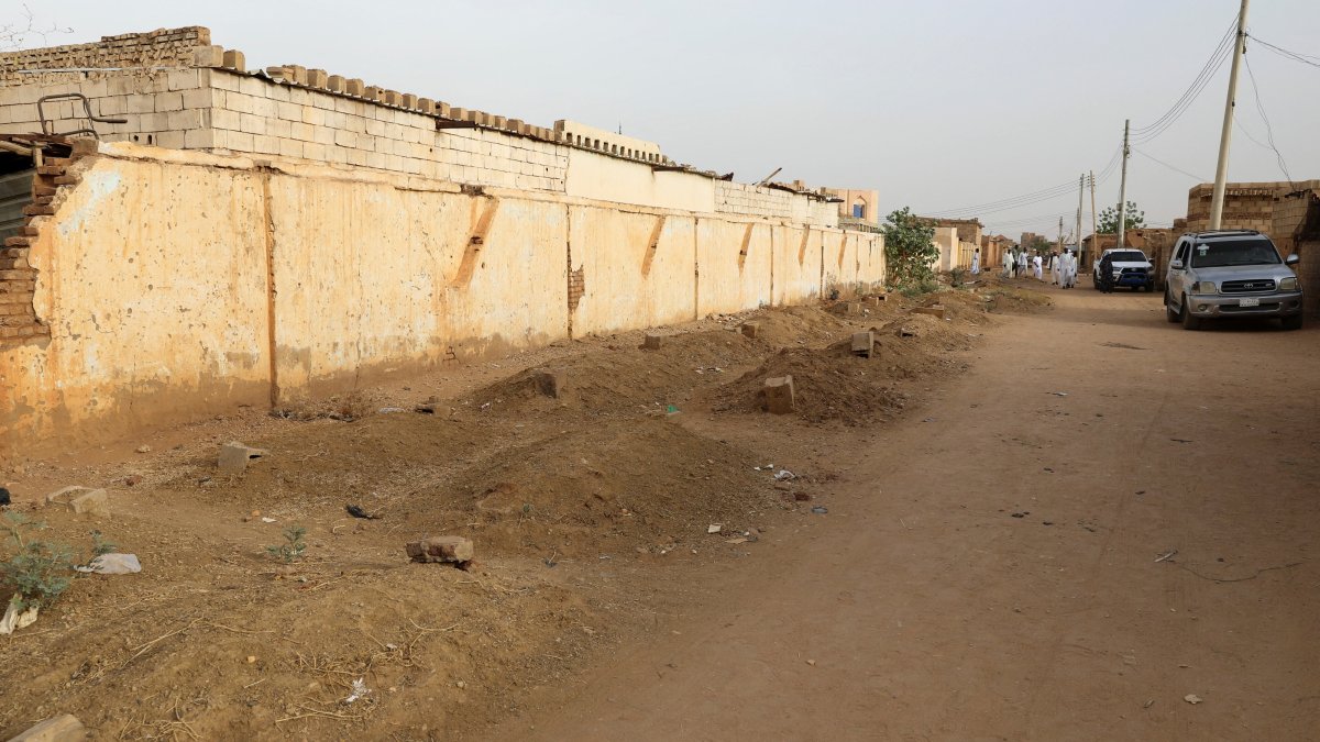 Graves line a street in the Salha neighborhood after the Rapid Support Forces (RSF) barred locals from burying their dead, south of Omdurman, Sudan, June 7, 2026. (Reuters Photo)
