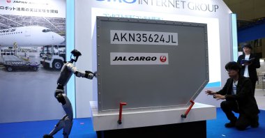 Humanoid robot Unitree G1 pushes a mock cargo container during an airport ground-handling demonstration at the GMO Internet Group booth during Japan Drone Expo 2026, Chiba, Japan, June 5, 2026. (Reuters Photo)