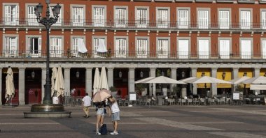 People use an umbrella to cover from the sun at Plaza Mayor in Madrid, Spain, June 23, 2026. (Getty Images Photo)