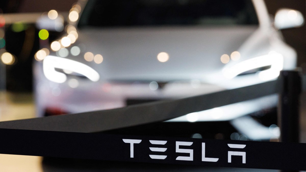 This photograph shows the logo of U.S. automobile manufacturer Tesla next to a Tesla car during a press opening of the 102th edition of the Brussels Motor Show at Brussels Expo, Brussels, Belgium, Jan. 9, 2026. (AFP Photo)