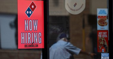 A now-hiring sign is posted in the window of a Domino's Pizza restaurant in Los Angeles, California, U.S., June 5, 2026. (AFP Photo)