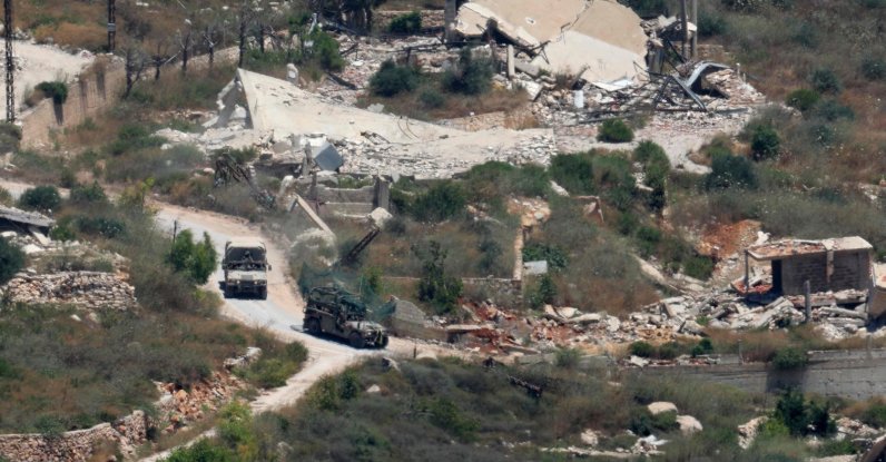 Israeli military vehicles drive past houses destroyed in Israeli strikes in the southern Lebanese village near the Israel-Lebanon border, July 1, 2026. (AFP Photo)